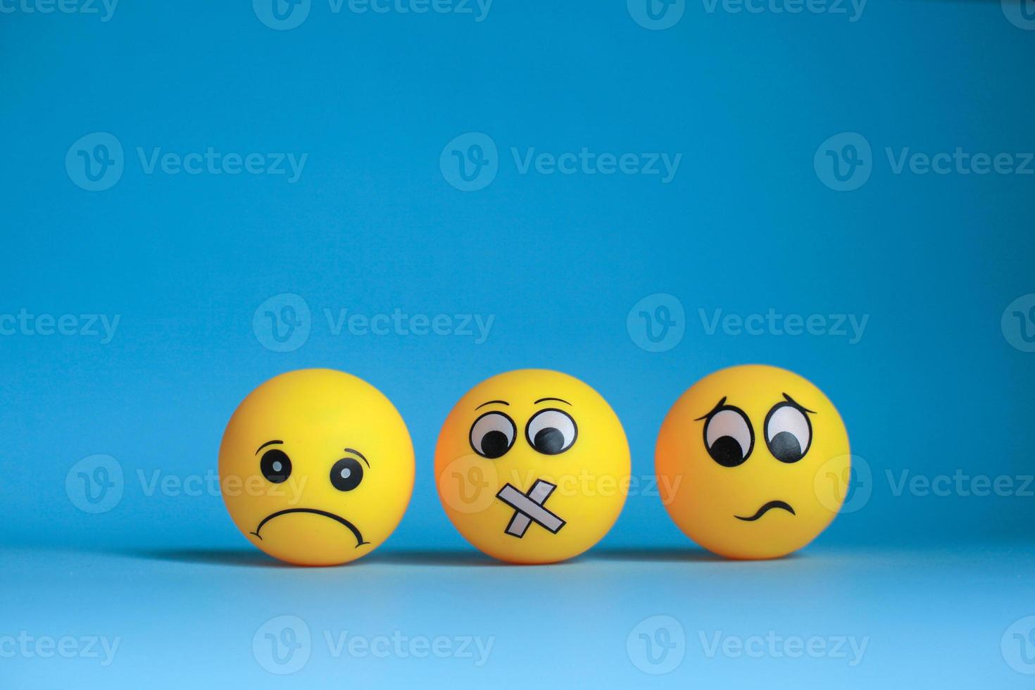 emoticon triste con emoticon faccia silenziosa ed emoticon confusa su sfondo blu foto