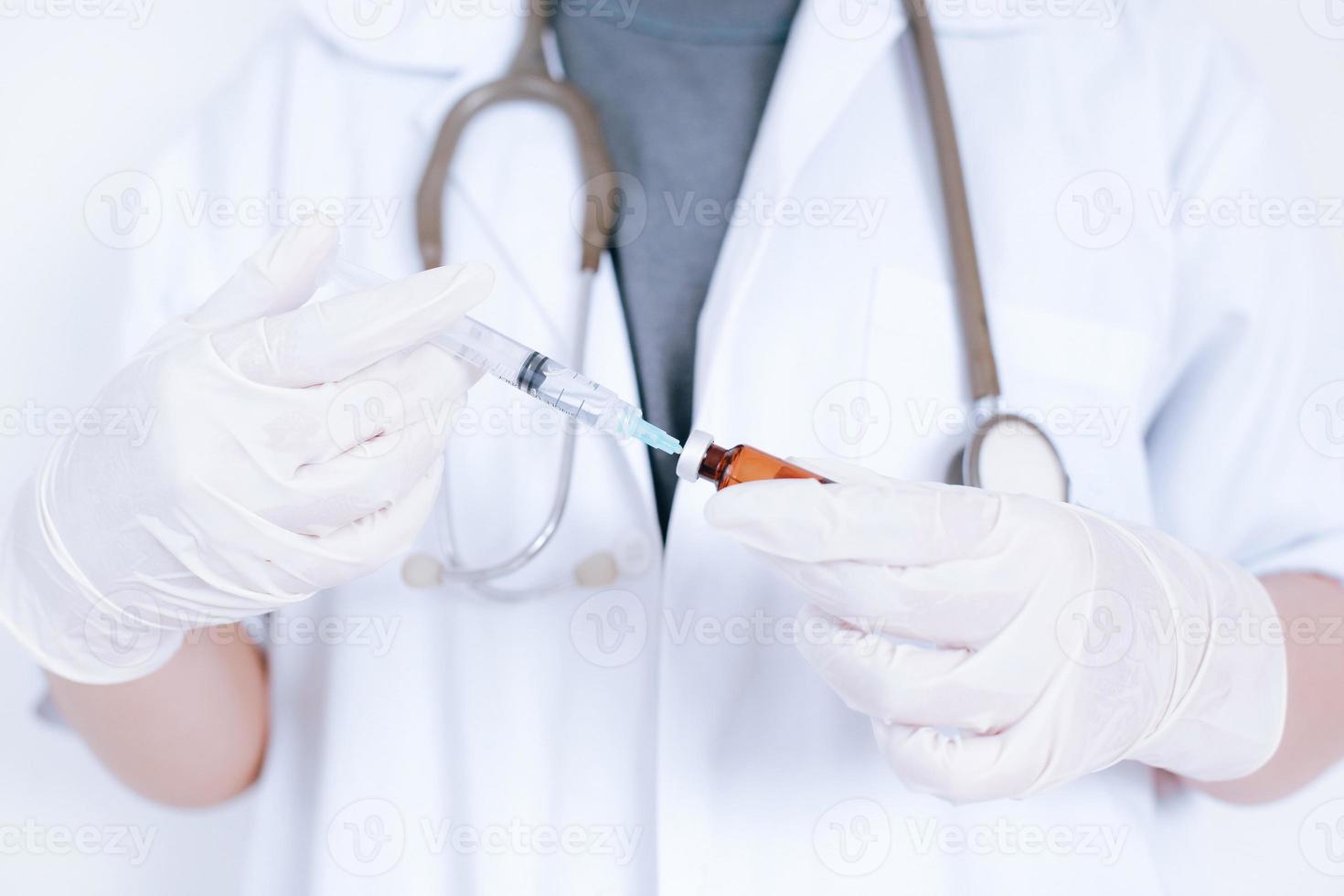 il colpo ritagliato della mano del medico tiene la siringa e il flacone con il vaccino. concetto di medicina, vaccinazione, immunizzazione e assistenza sanitaria foto