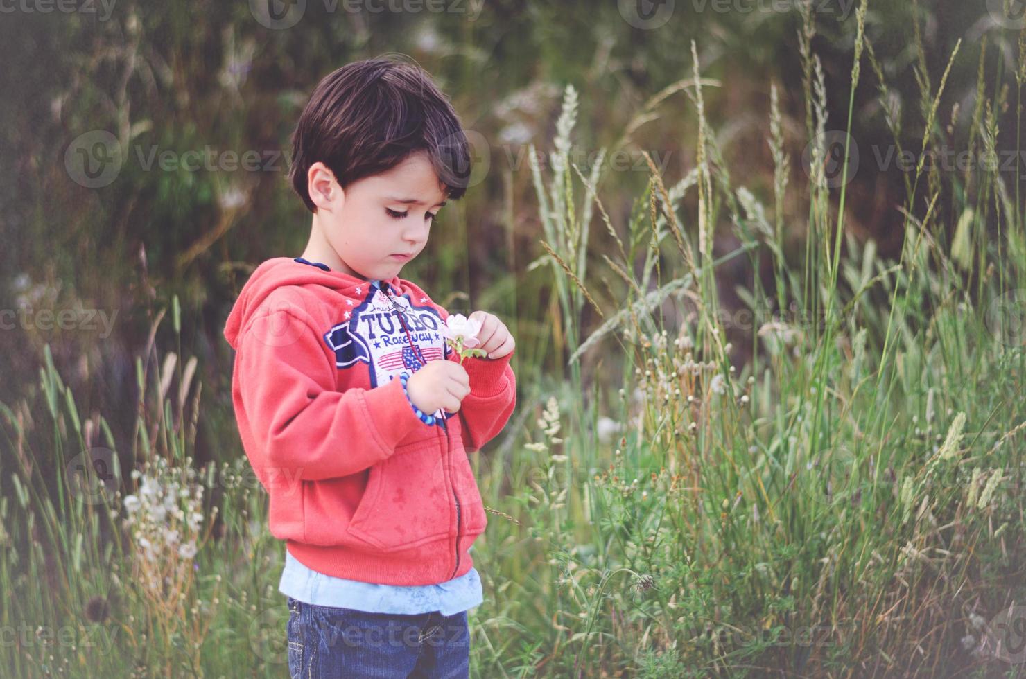 bambino triste con un fiore foto