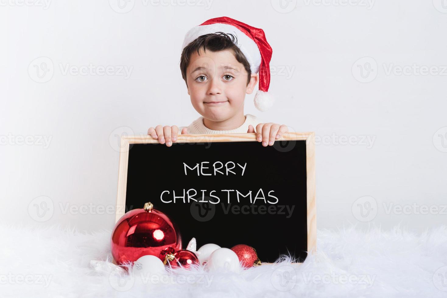 ragazzo sorridente con una lavagna a natale foto