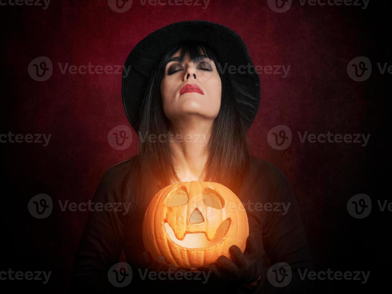 bella giovane donna come strega con la zucca foto