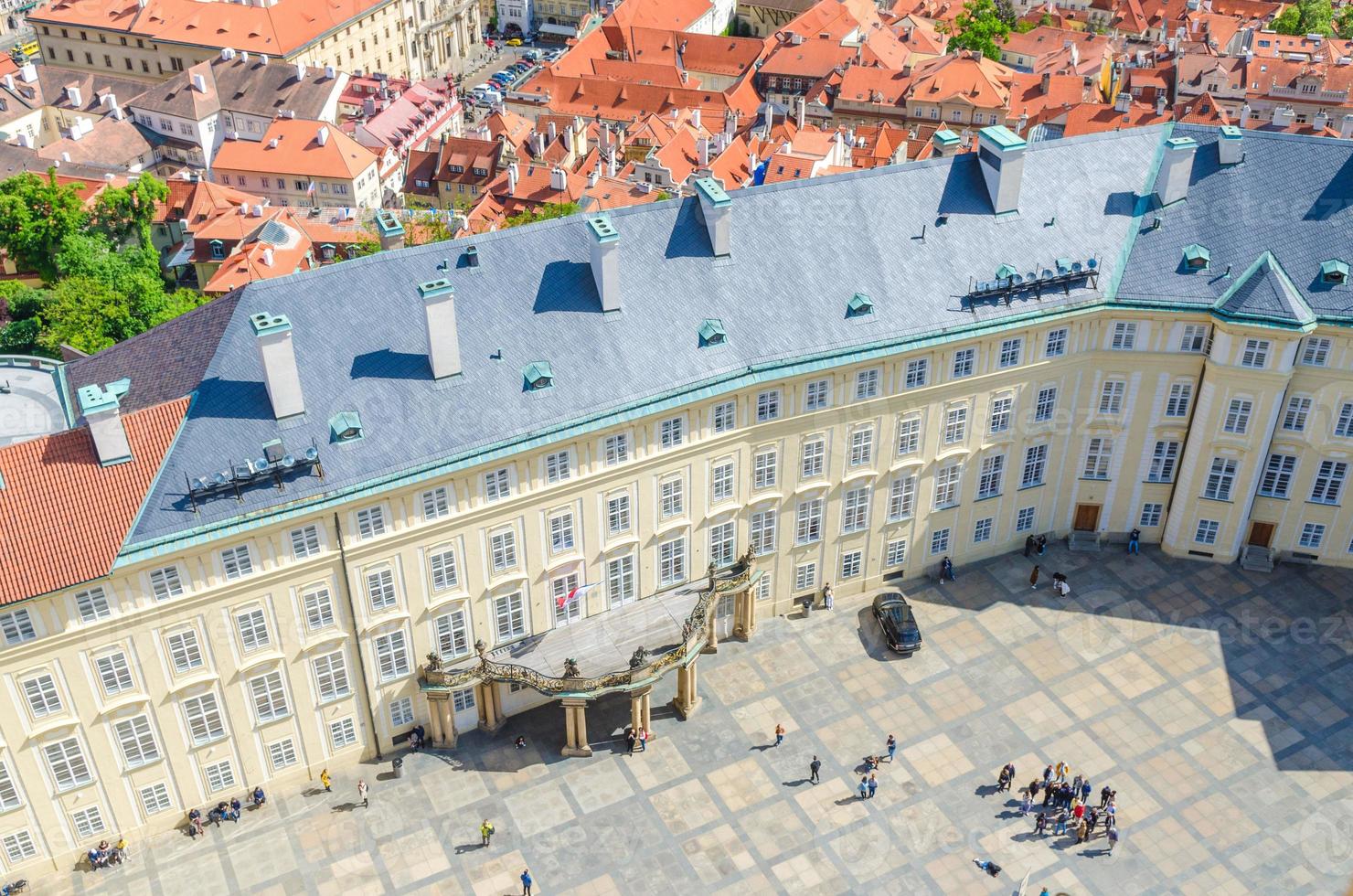 vista dall'alto della piazza del cortile del castello di praga e del vecchio palazzo reale con piccole figure di persone che camminano foto