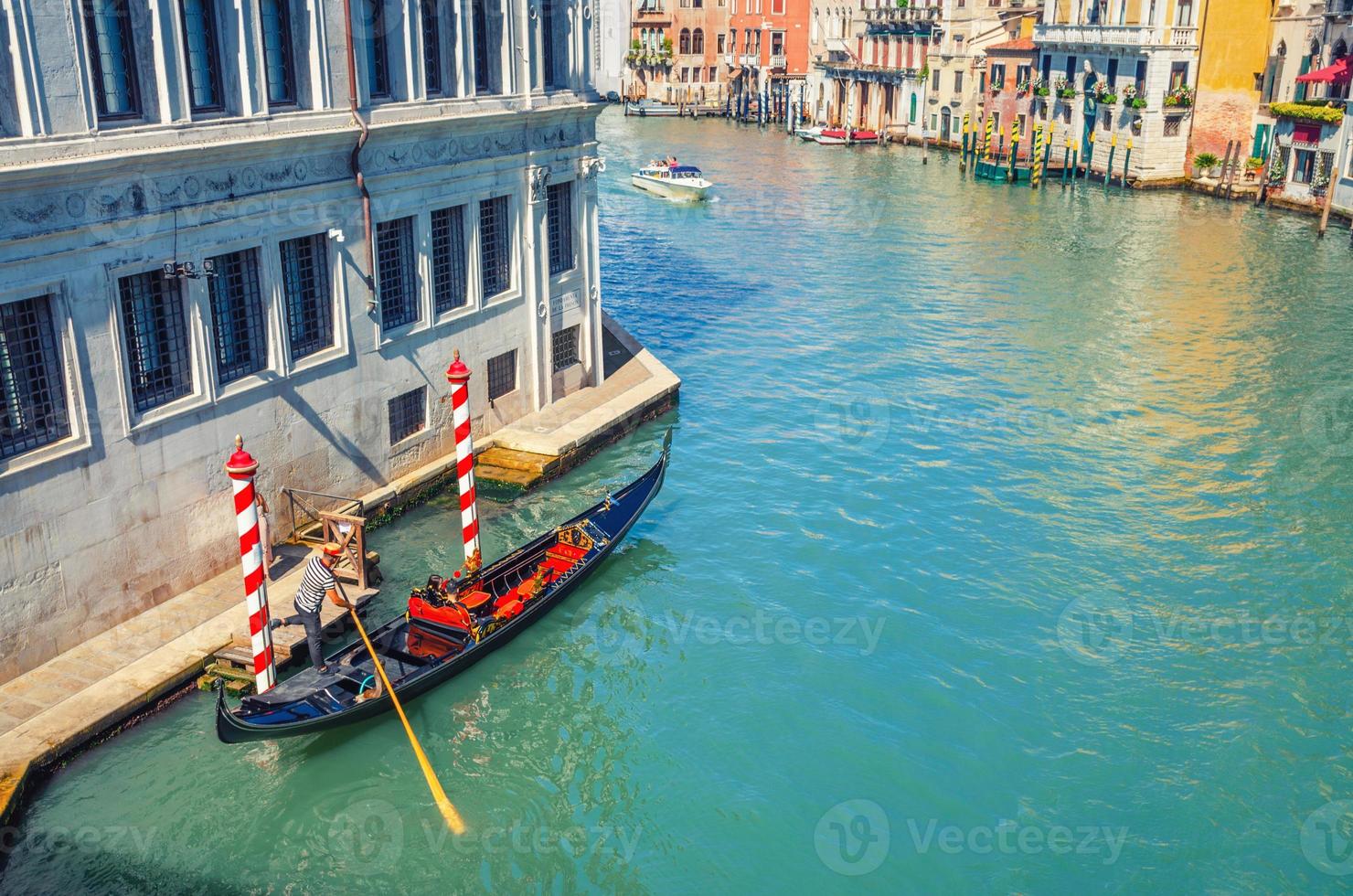 gondoliere sulla gondola a vela barca tradizionale nell'acqua del canale navigabile a venezia foto