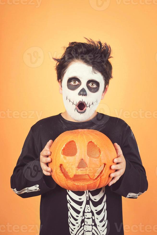 felice halloween.bambino divertente in un costume da scheletro con la zucca di Halloween sulla testa foto