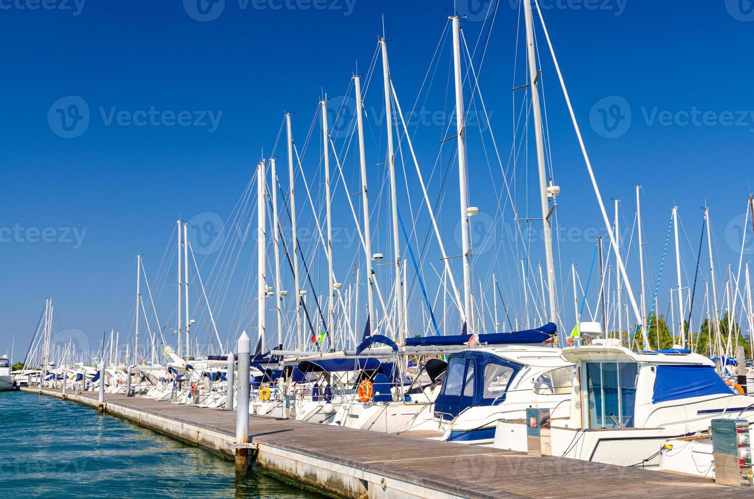 yacht bianchi sono ormeggiati sull'acqua del molo parcheggio nel porto turistico porto della città di sottomarina foto