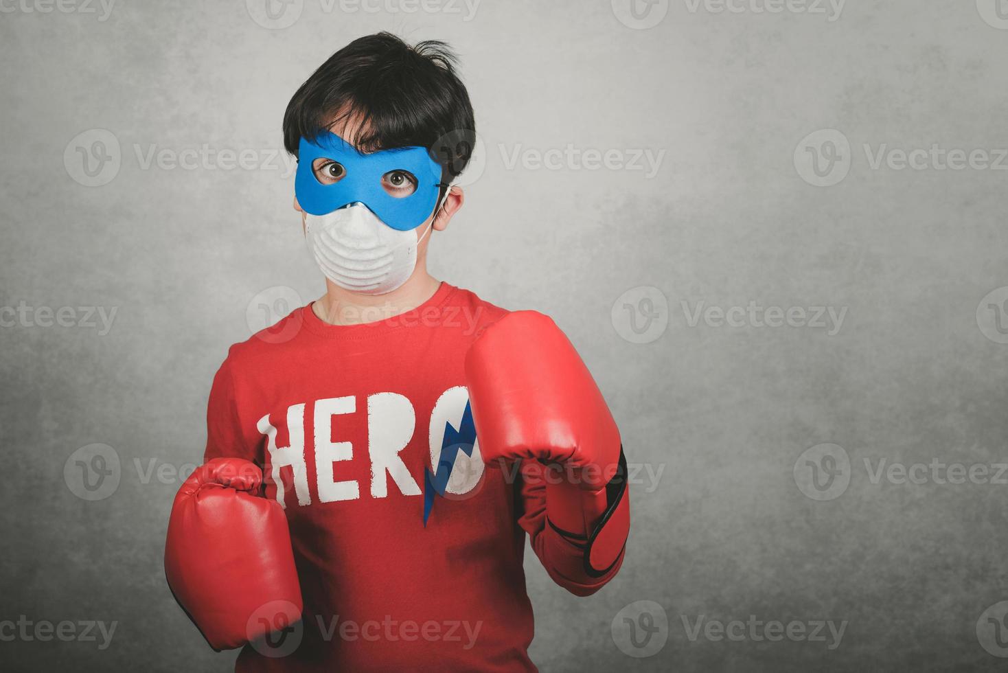 coronavirus, bambino che indossa una maschera per il coronavirus vestito da supereroe foto