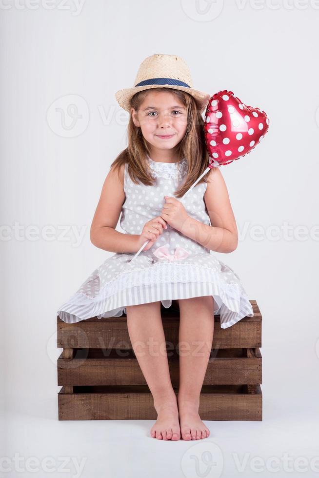 ragazza felice con un palloncino a forma di cuore foto