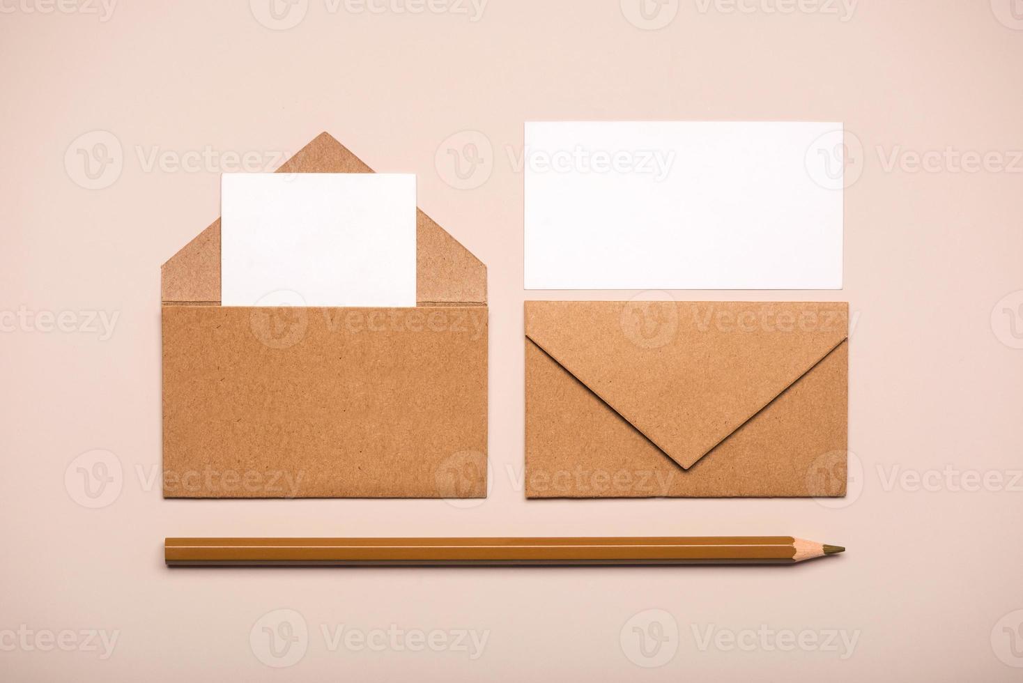 buste di carta marrone con cartoncini bianchi e matita marrone foto
