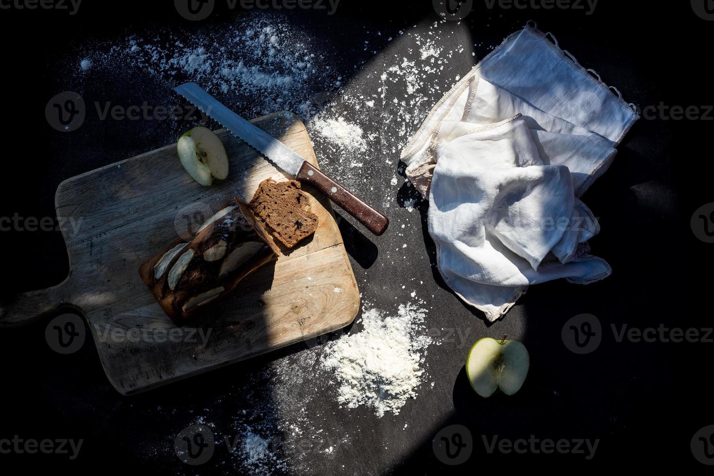 tavola nera con un biscotto e una mela foto