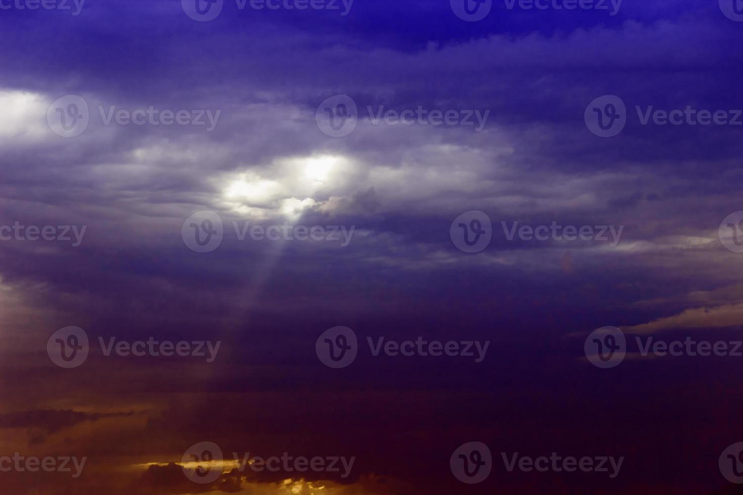 tra le nuvole sul mare si fa strada un raggio di sole foto