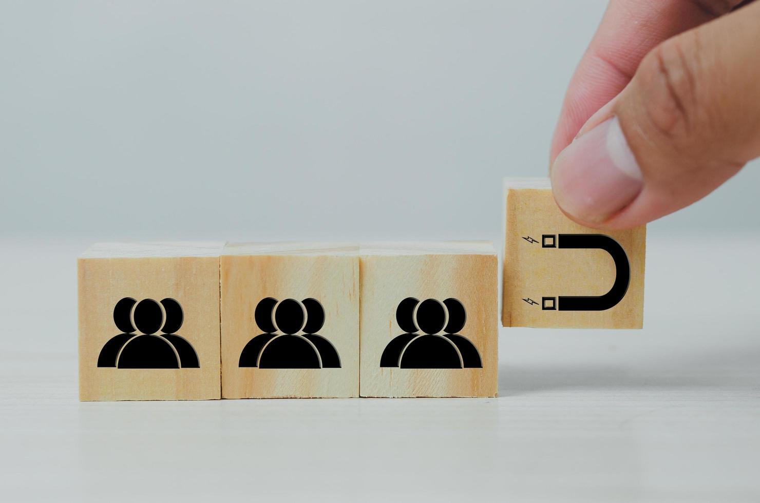 cubo di legno con icone di persone e magnete. concetto di marketing inbound marketing digitale. foto