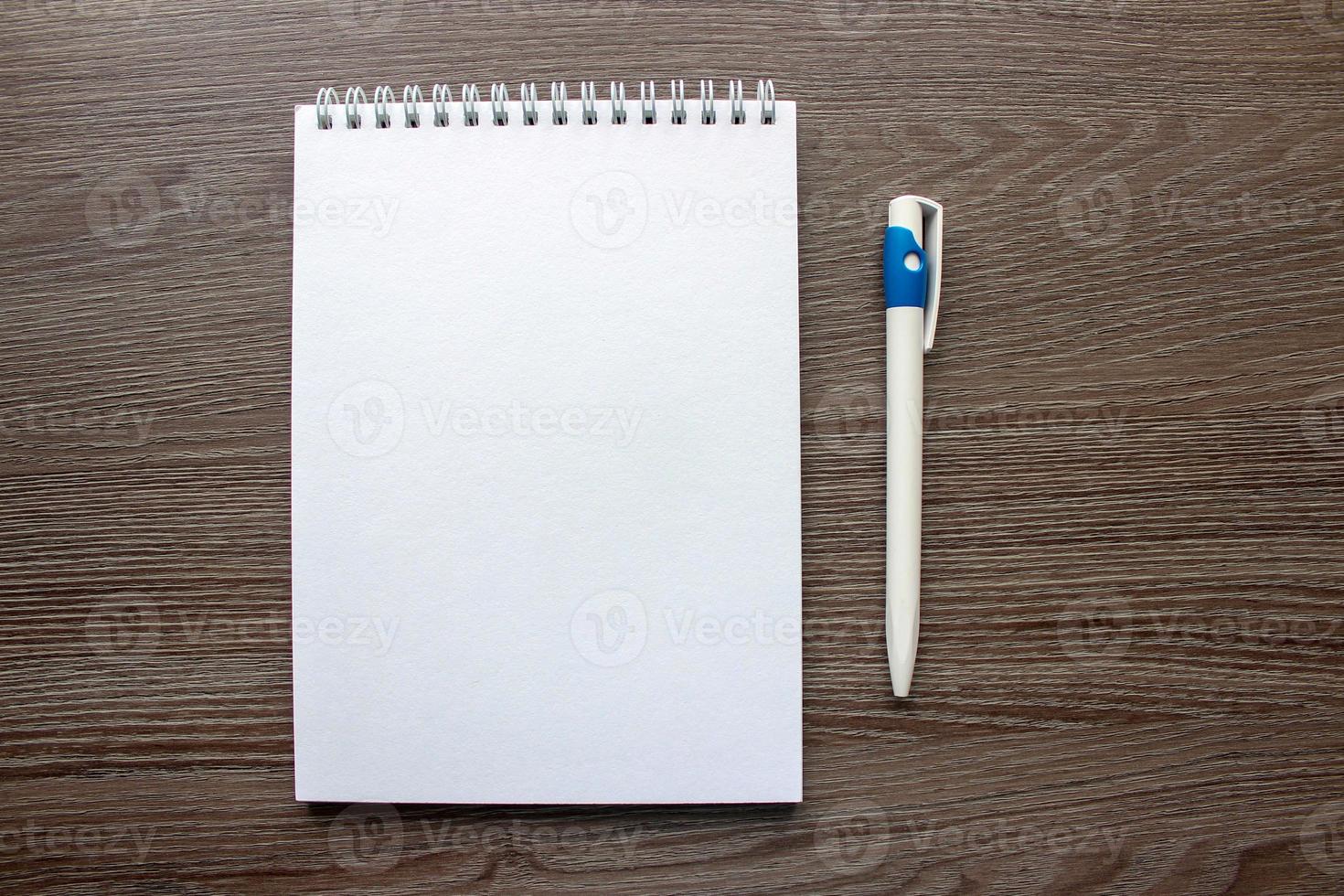 quaderno e penna su fondo in legno foto