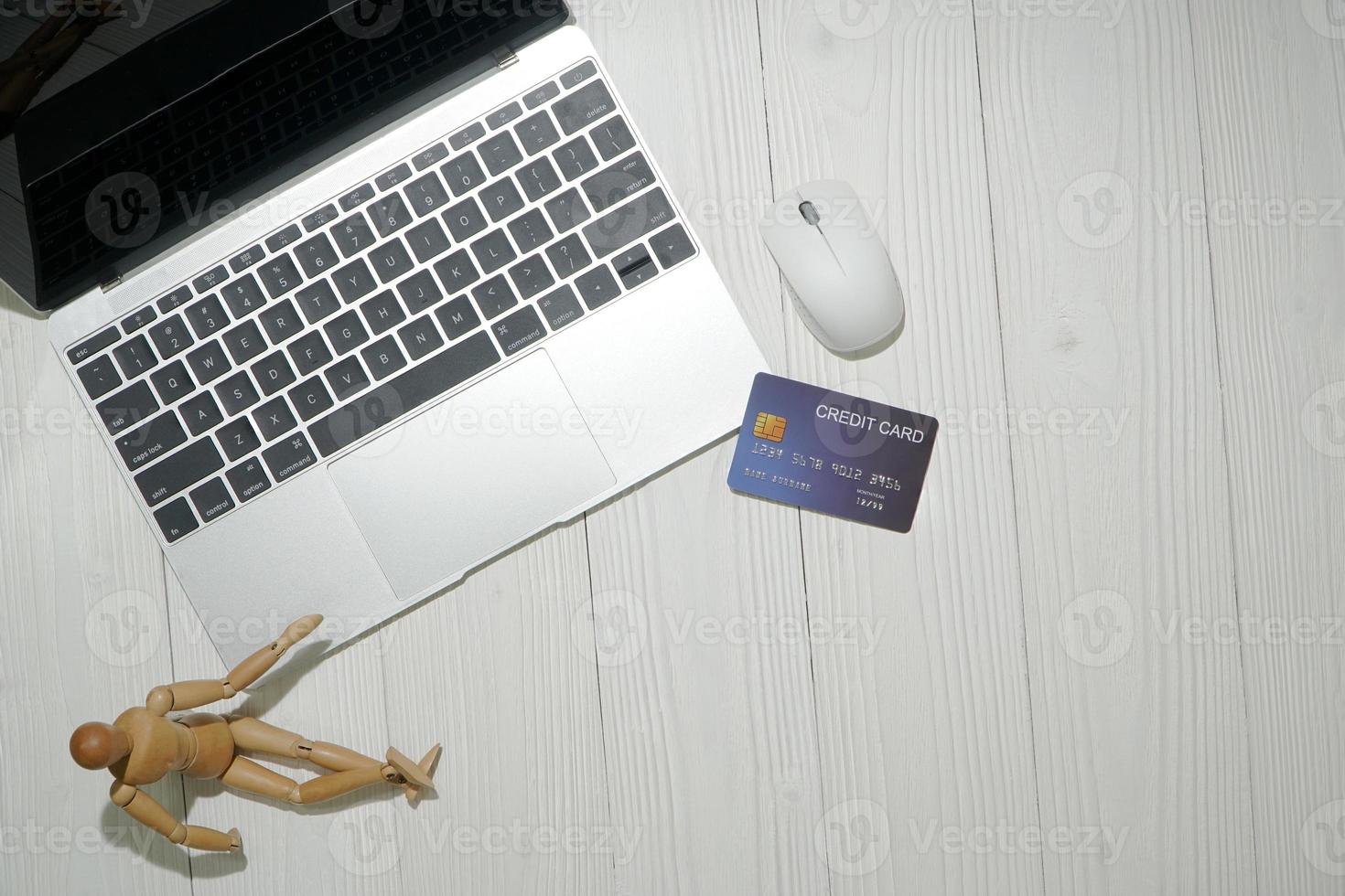 vista dall'alto del laptop con carta di credito su una superficie bianca foto