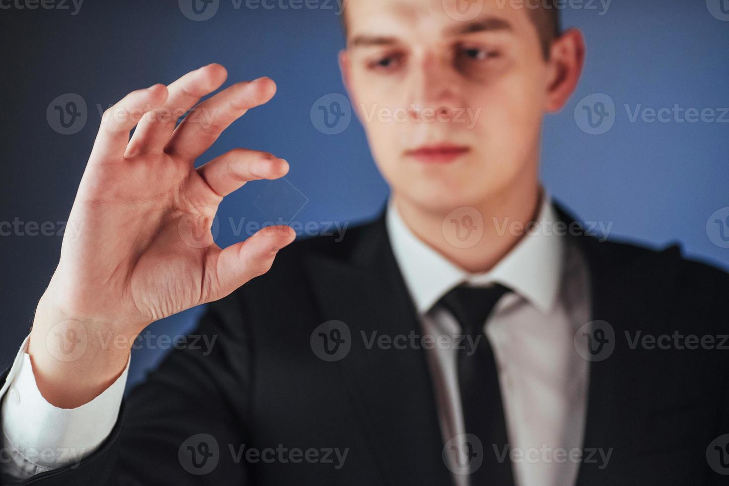 il giovane uomo d'affari in un vestito mostra la sua mano foto