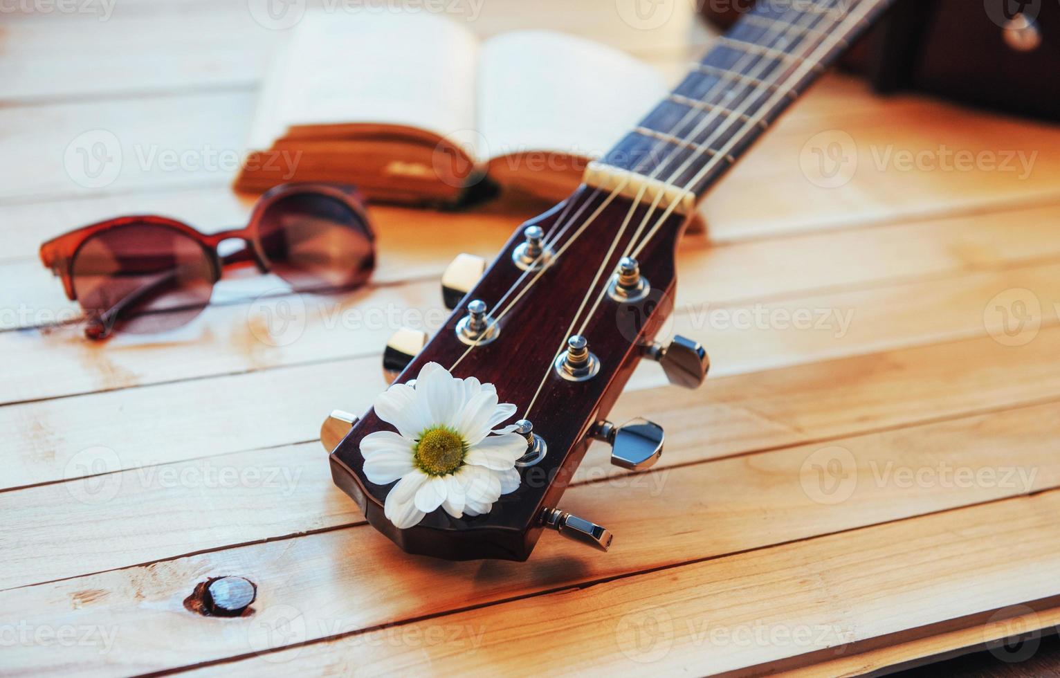 primo piano testa di chitarra classica con occhiali e libro foto