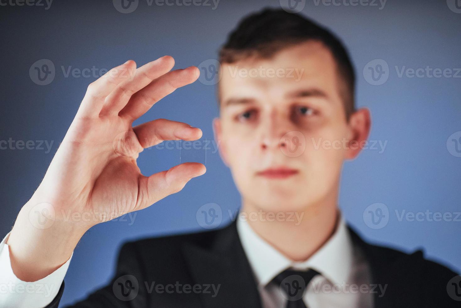 il giovane uomo d'affari in un vestito mostra la sua mano foto