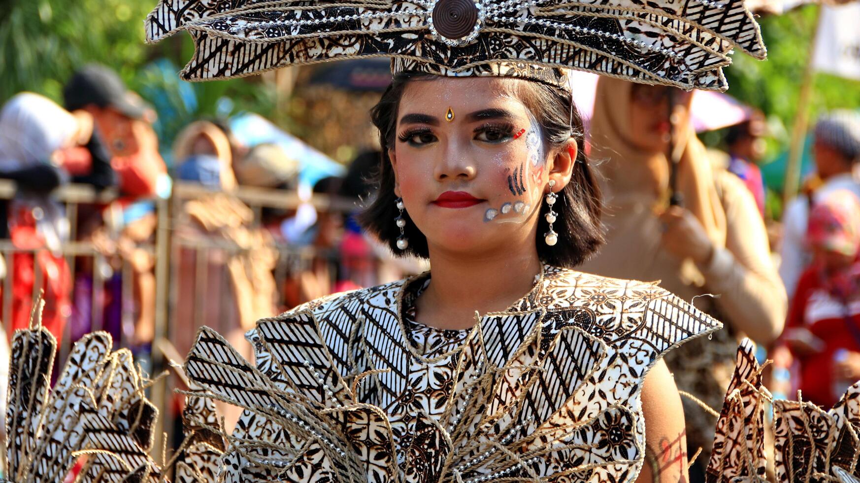 partecipanti in un costume batik modificato mentre sono in azione al 113° anniversario della parata della città di Pekalongan foto