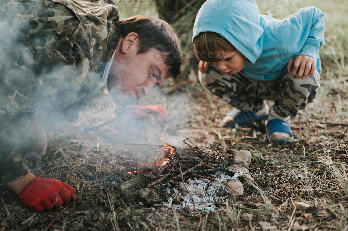 padre figlio bambino falò campagna foto