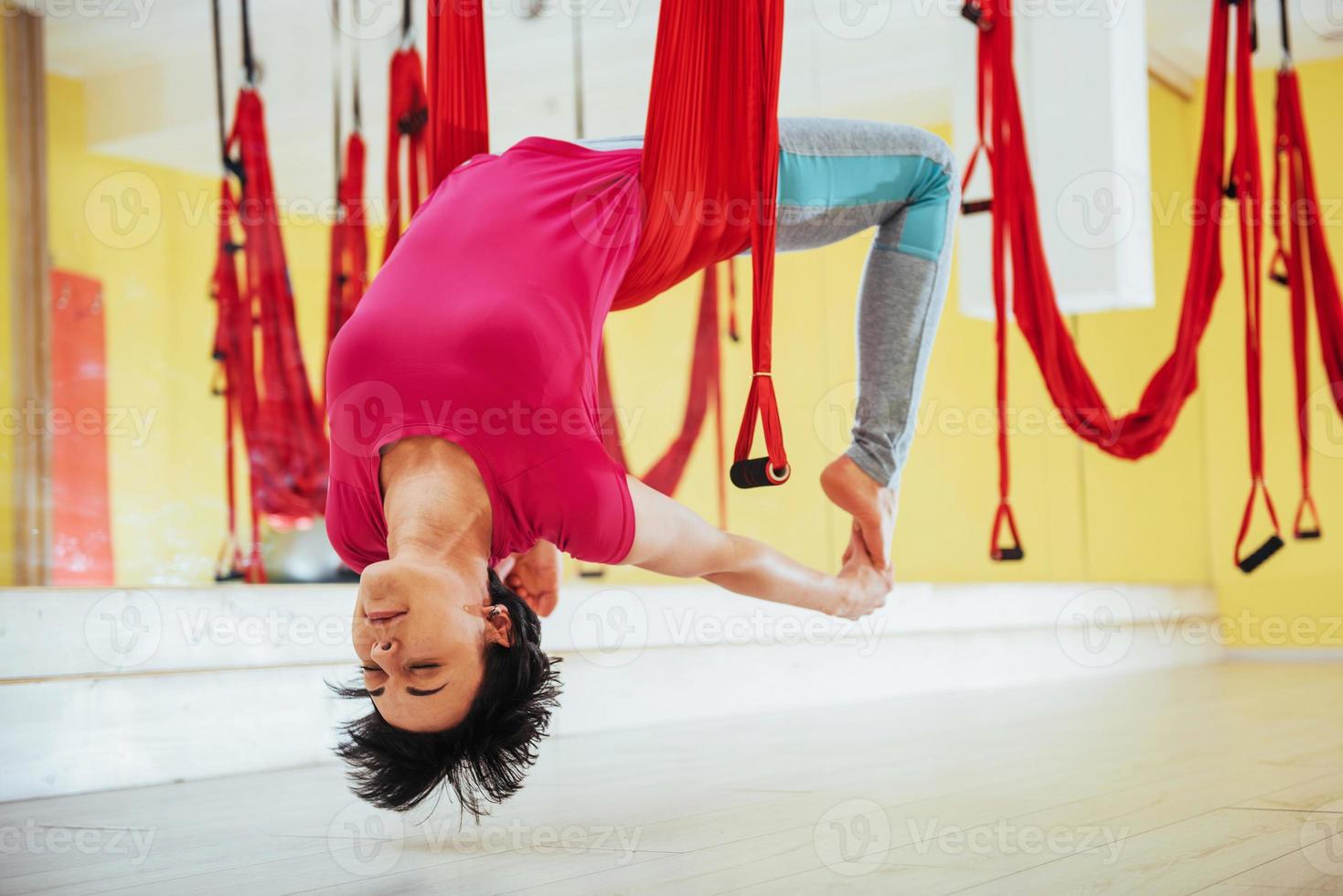 giovane bella donna che pratica yoga vola con un'amaca nello studio  luminoso. il concetto di salute mentale e fisica. 6202473 Stock Photo su  Vecteezy