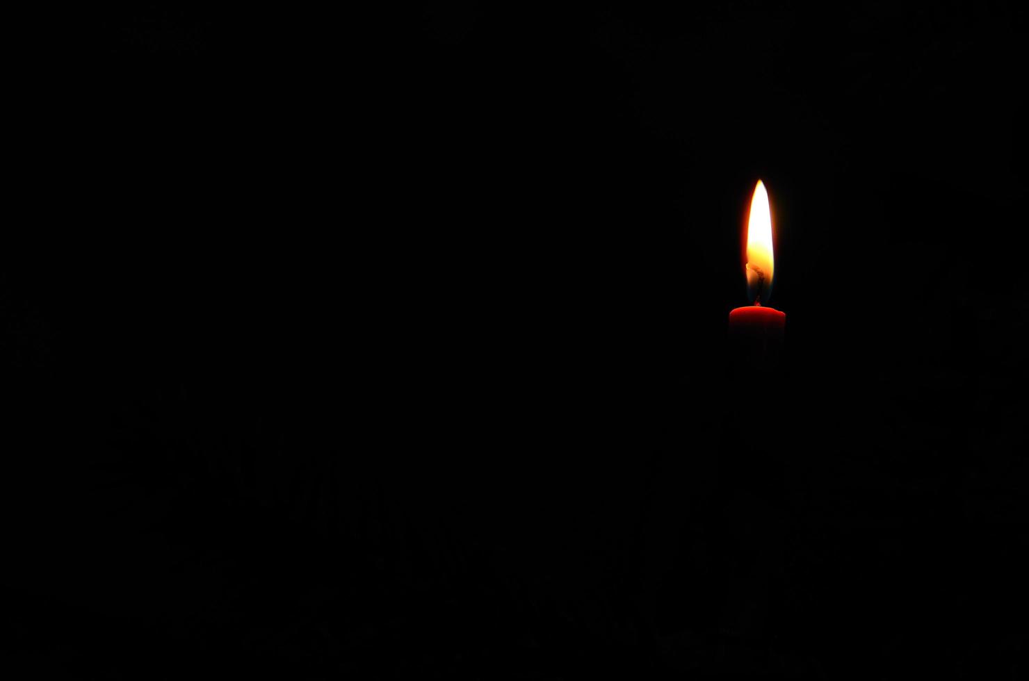 candela accesa nel buio foto
