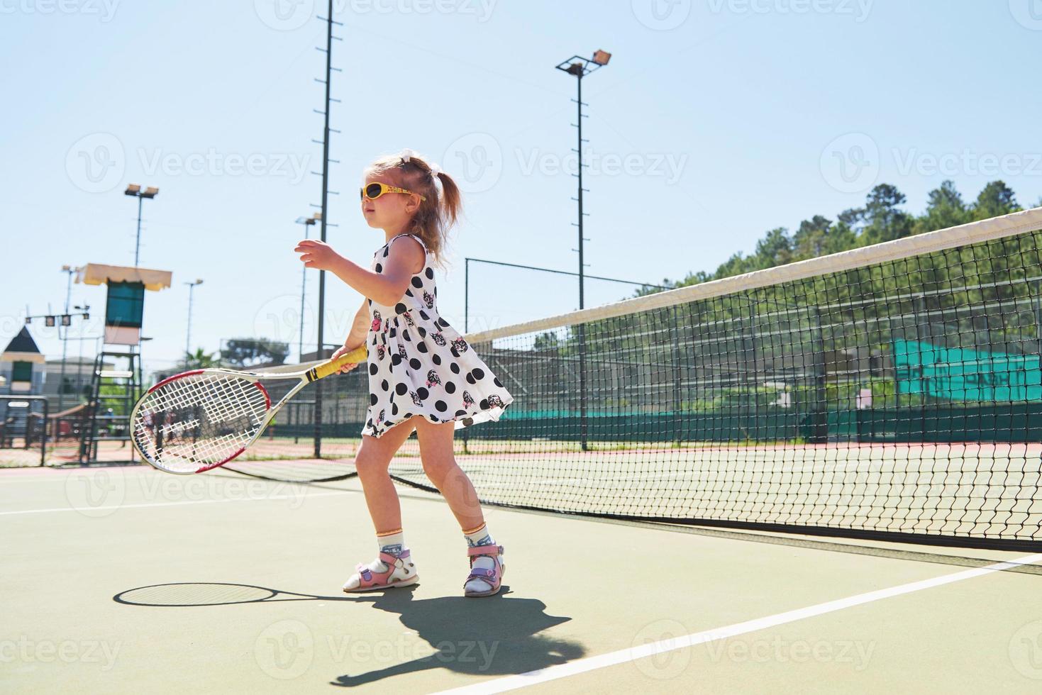 ragazza carina che gioca a tennis e posa per la fotocamera foto