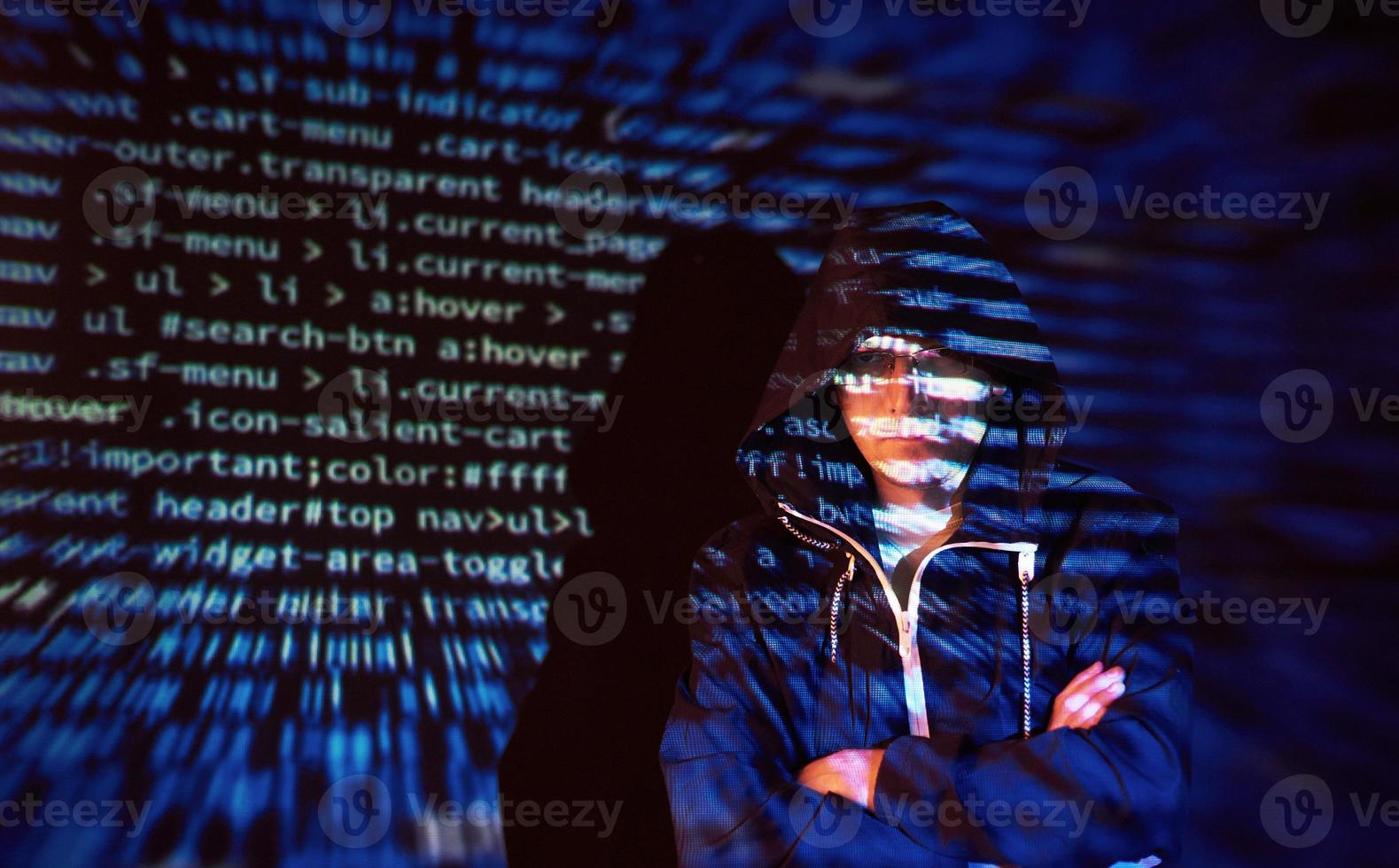 attacco informatico con hacker incappucciato irriconoscibile che utilizza la realtà virtuale, effetto glitch digitale foto