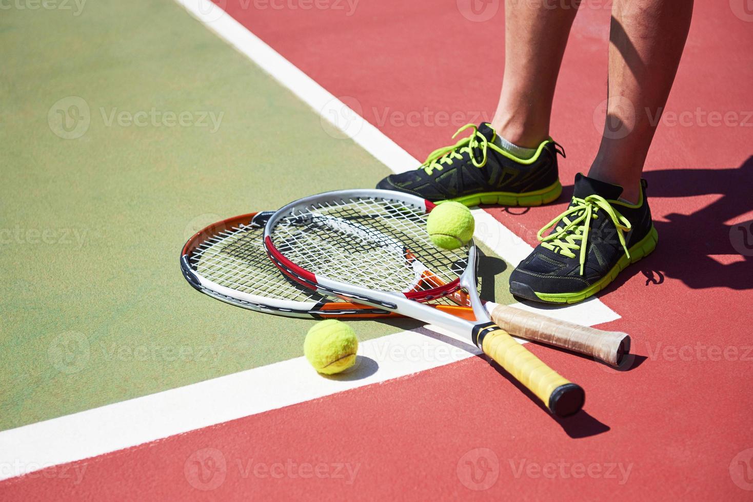 una racchetta da tennis e una pallina da tennis nuova su un campo da tennis dipinto di fresco foto