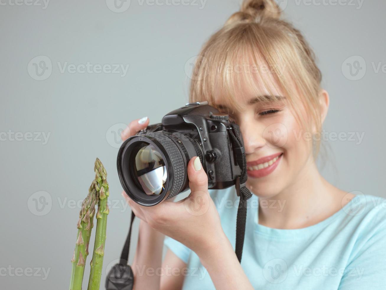 fotografo di giovane donna che riprende un asparagi con la fotocamera digitale. primo piano, tiro, hobby, concetto di professione foto