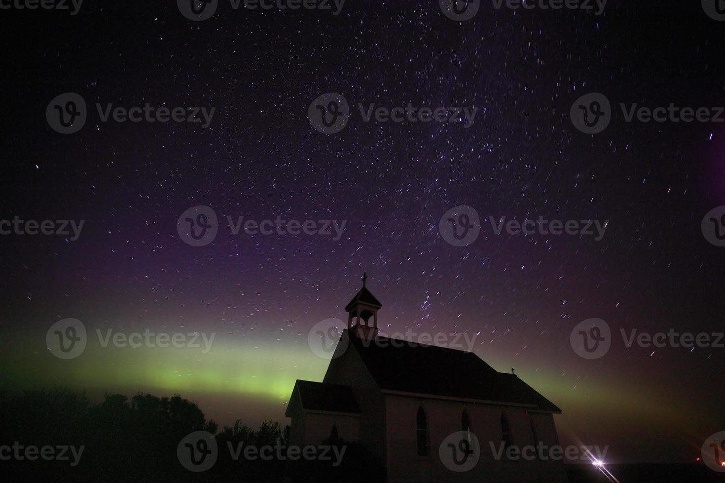 aurora boreale e tracce di stelle sopra la chiesa di San Colombano foto