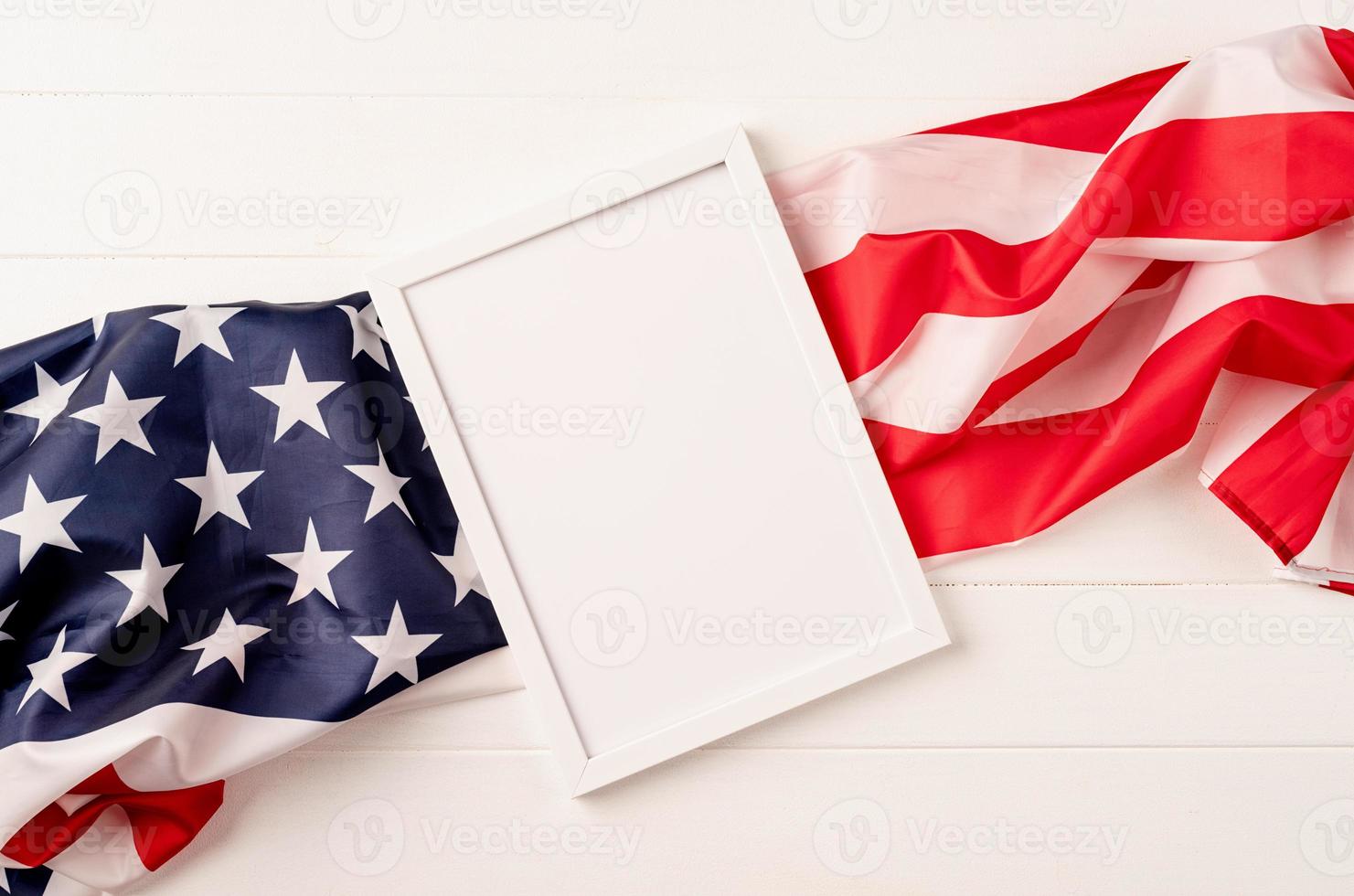 cornice bianca vuota per la progettazione di mockup su sfondo di legno bandiera nazionale americana foto