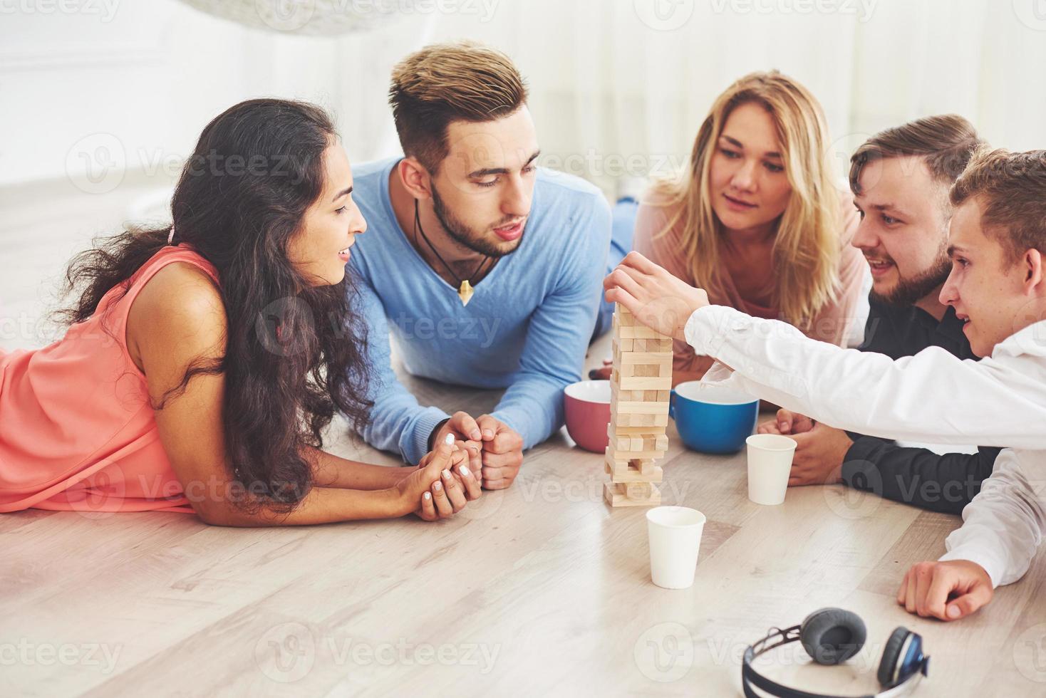 gruppo di amici creativi seduti al tavolo di legno. persone che si divertono mentre giocano a giochi da tavolo foto