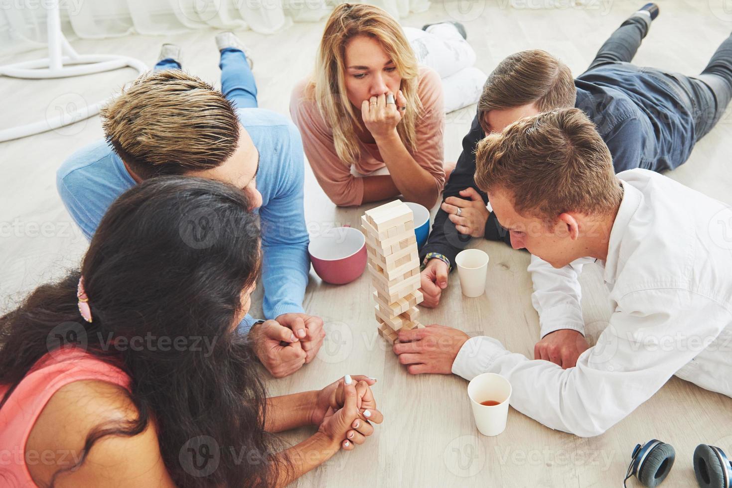 gruppo di amici creativi seduti al tavolo di legno. persone che si divertono mentre giocano a giochi da tavolo foto