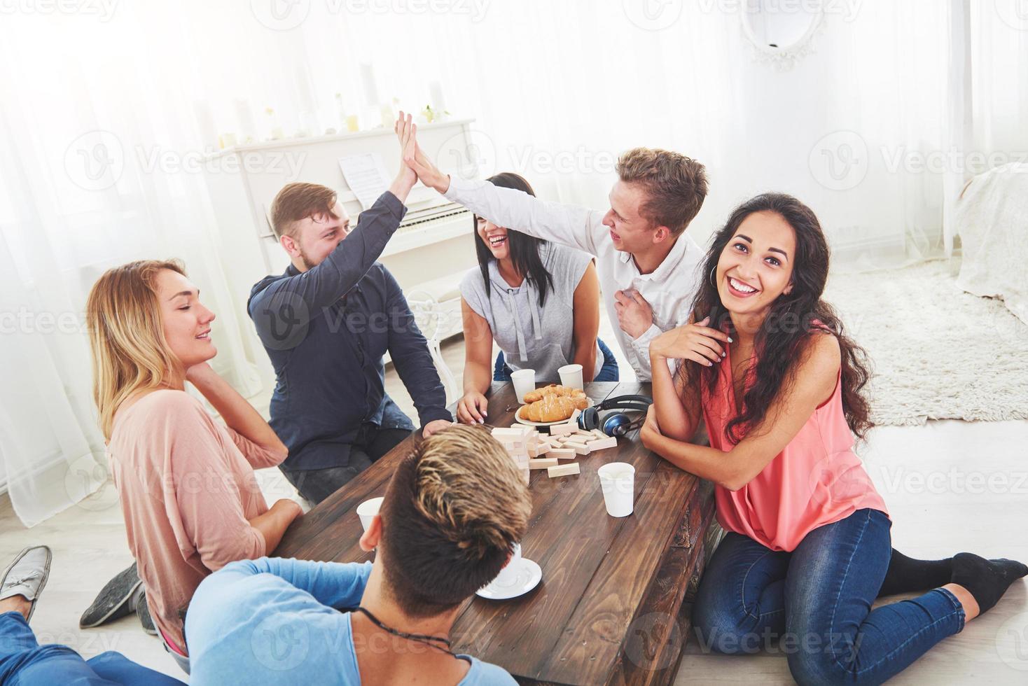 gruppo di amici creativi seduti al tavolo di legno. persone che si divertono mentre giocano a giochi da tavolo foto