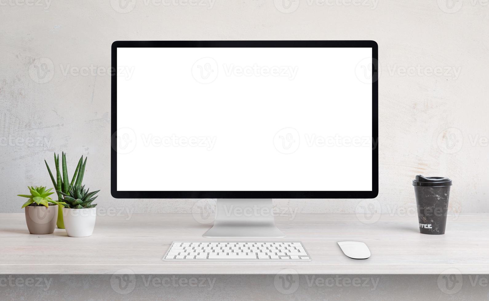 display del computer sulla scrivania con schermo bianco e isolato per la presentazione della pagina web foto