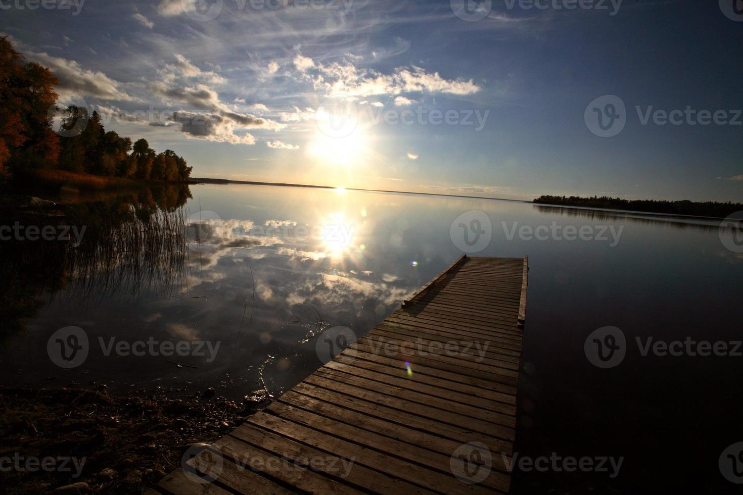 sole che tramonta su un molo di una barca del saskatchewan foto