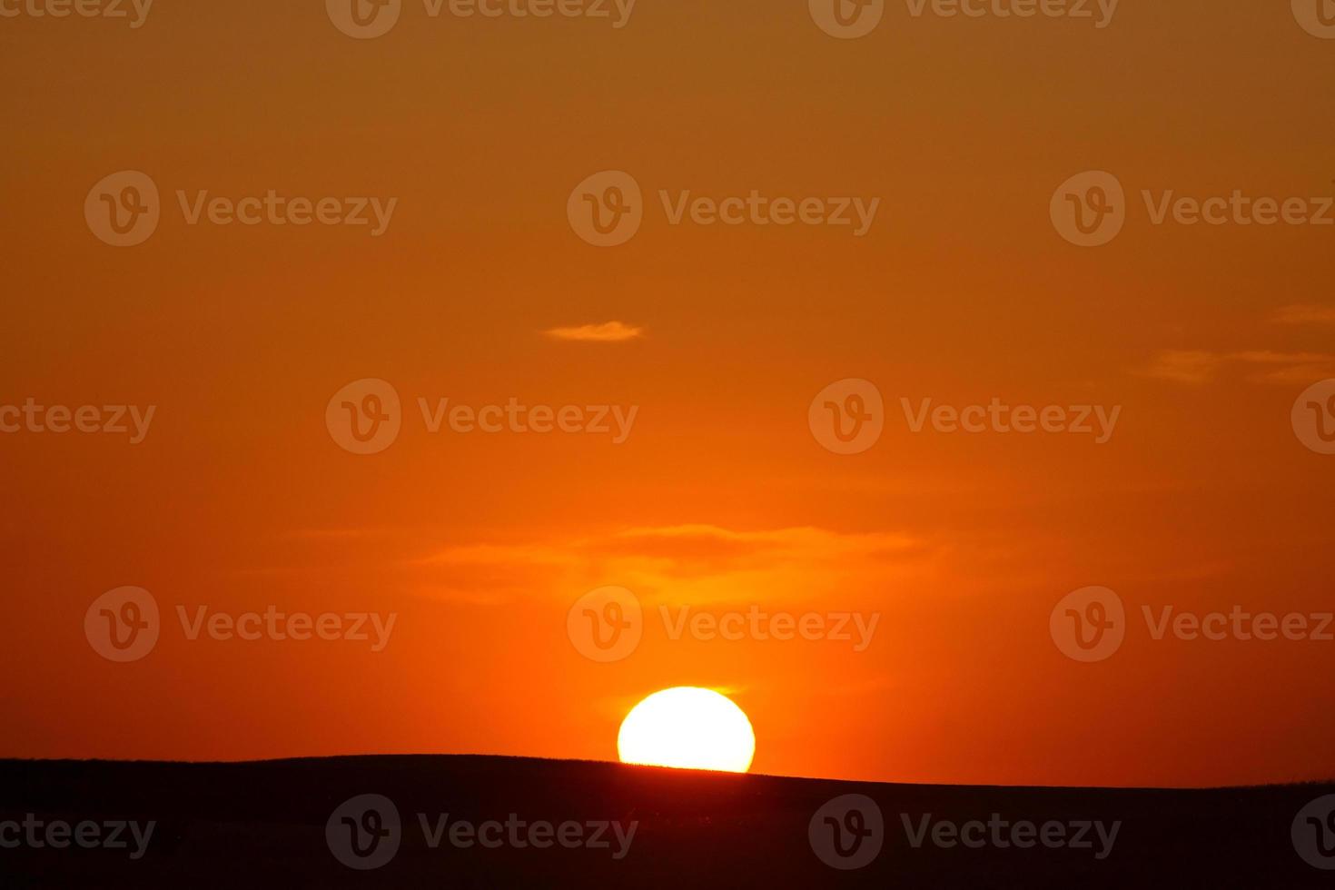 sole che tramonta all'orizzonte nel saskatchewan foto