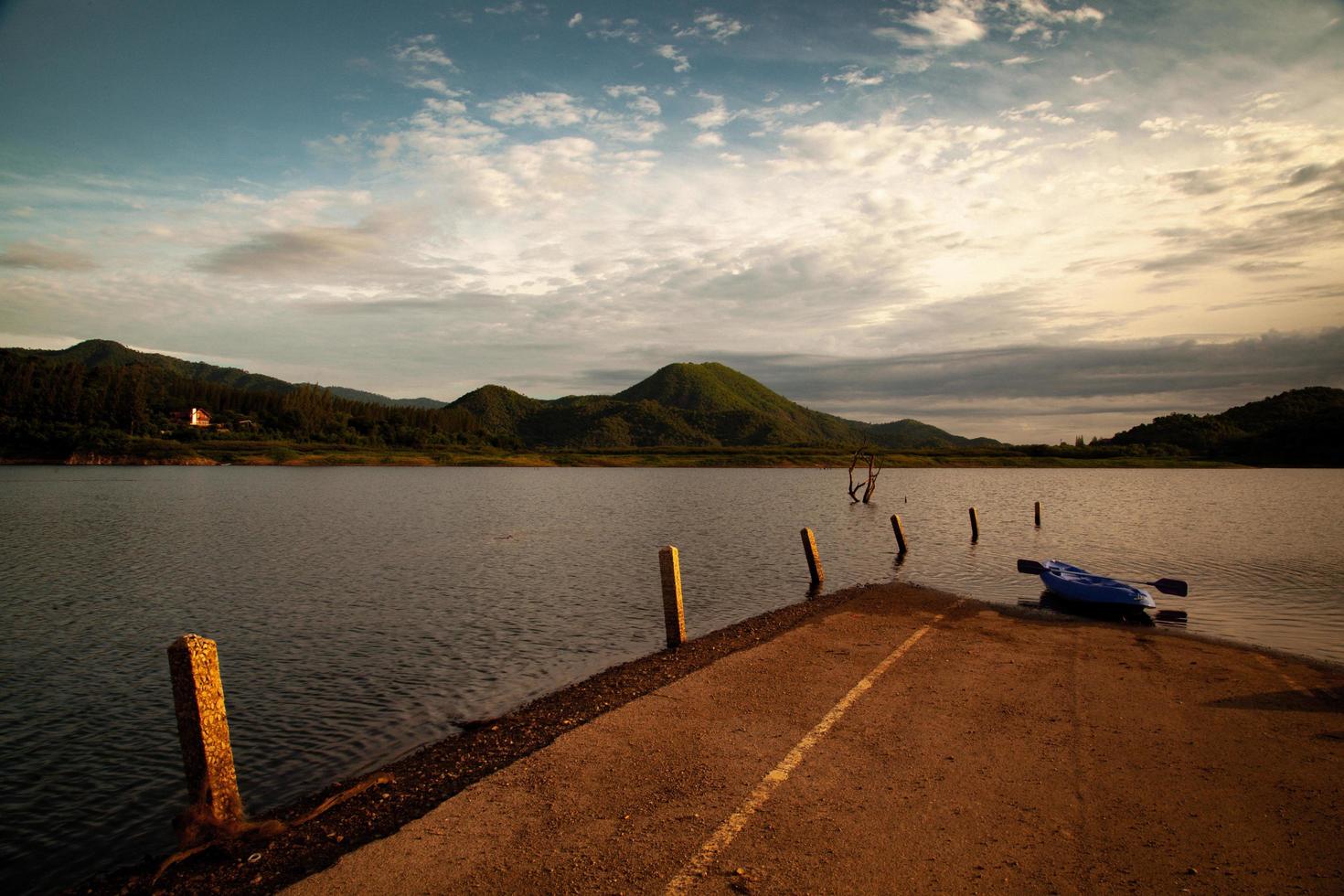 una barca blu nel lago del mattino foto