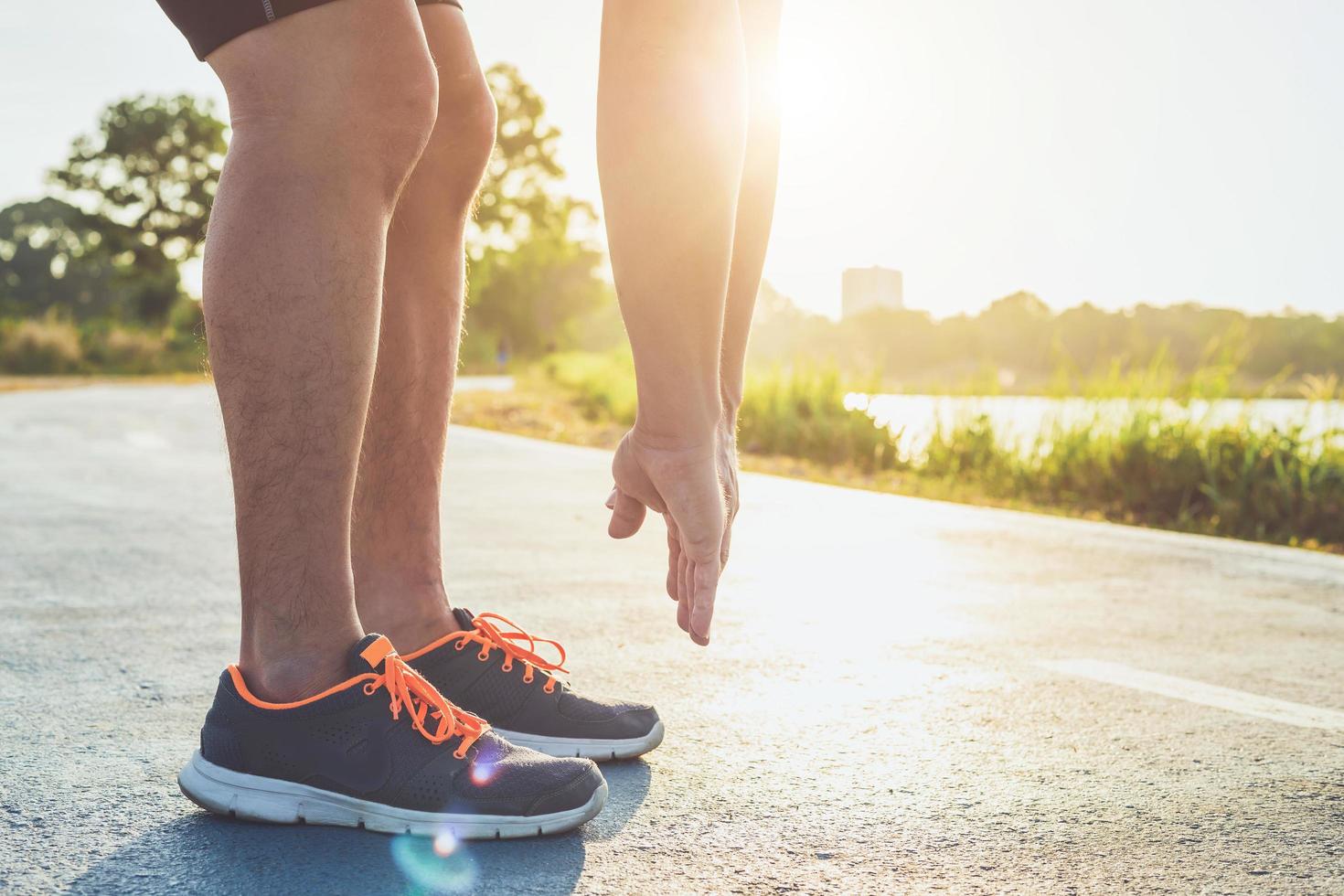 uomo allenamento benessere concetto piedi corridore con scarpa da ginnastica in esecuzione su strada nel parco. concentrarsi sulla scarpa. girato al mattino, luce solare ed effetto caldo con spazio di copia per testo o design foto