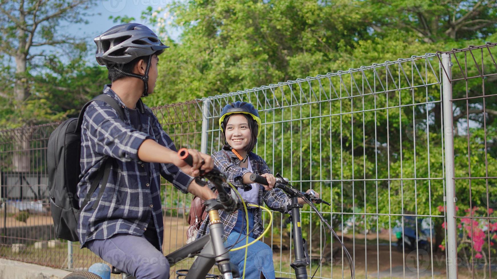 le giovani coppie asiatiche vanno in bicicletta insieme per andare al lavoro foto