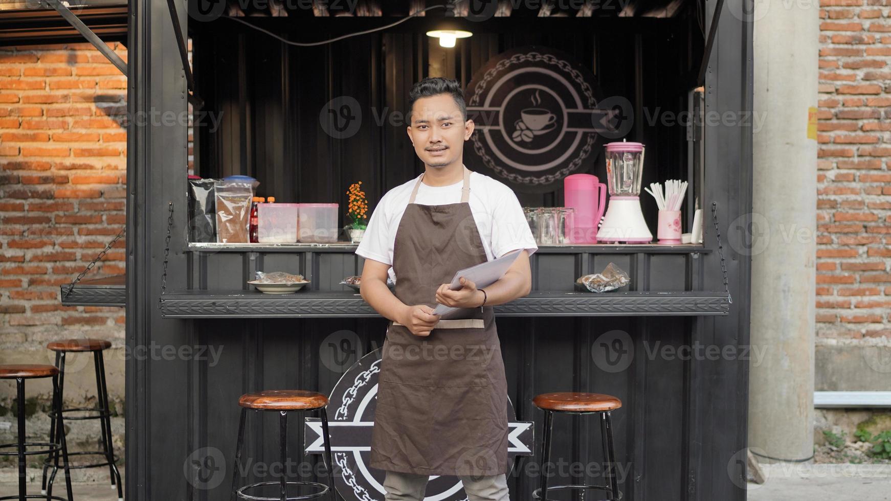 barista asiatico pronto ad aprire un negozio a tema container foto