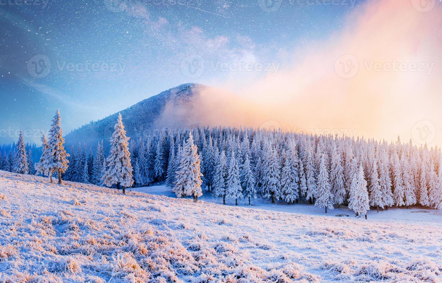 bellissimo paesaggio invernale nelle montagne dei Carpazi. cielo notturno vibrante con stelle, nebulose e galassie. astrofotografia del cielo profondo foto