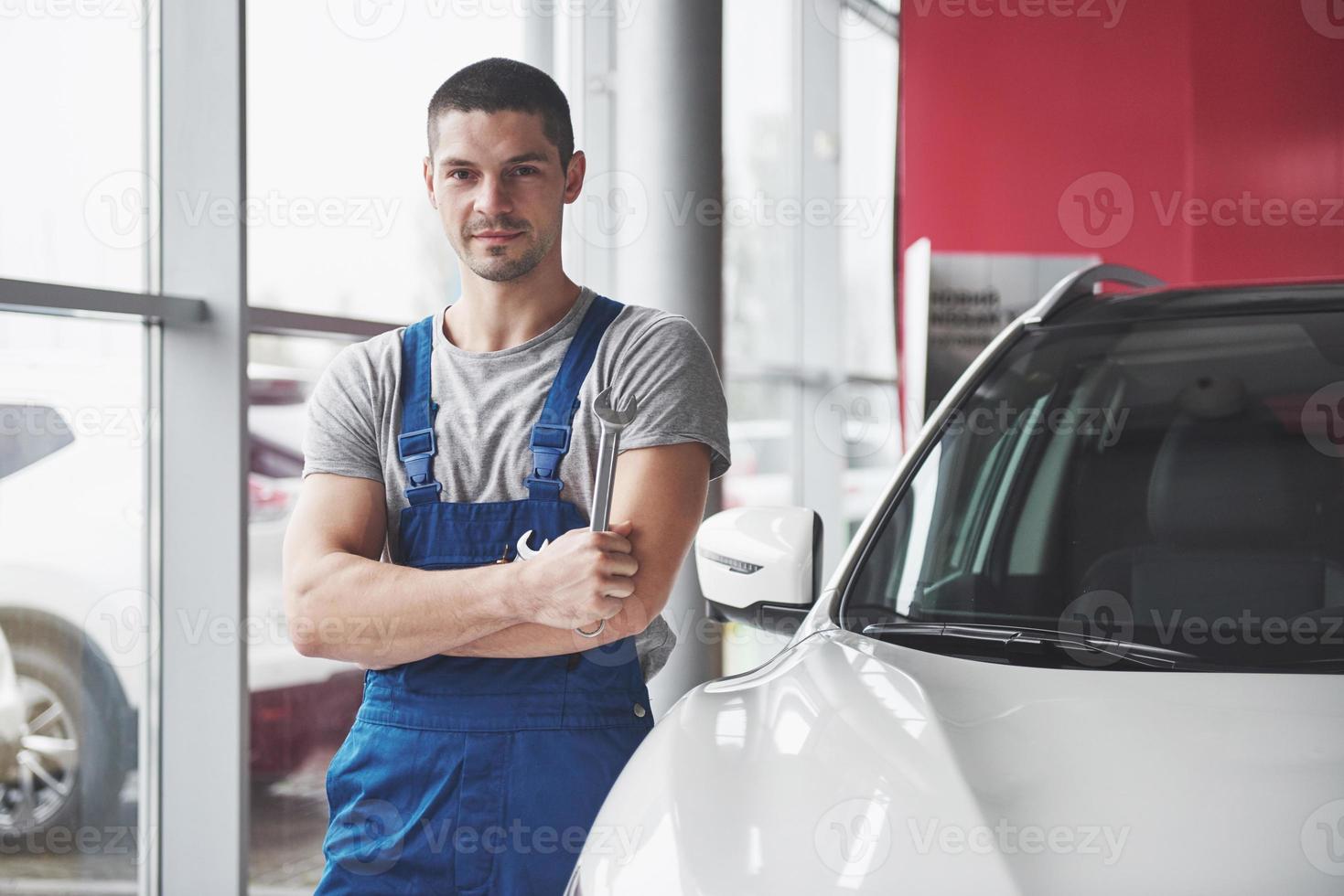 mano del meccanico di automobile con la chiave inglese. officina di riparazione auto foto