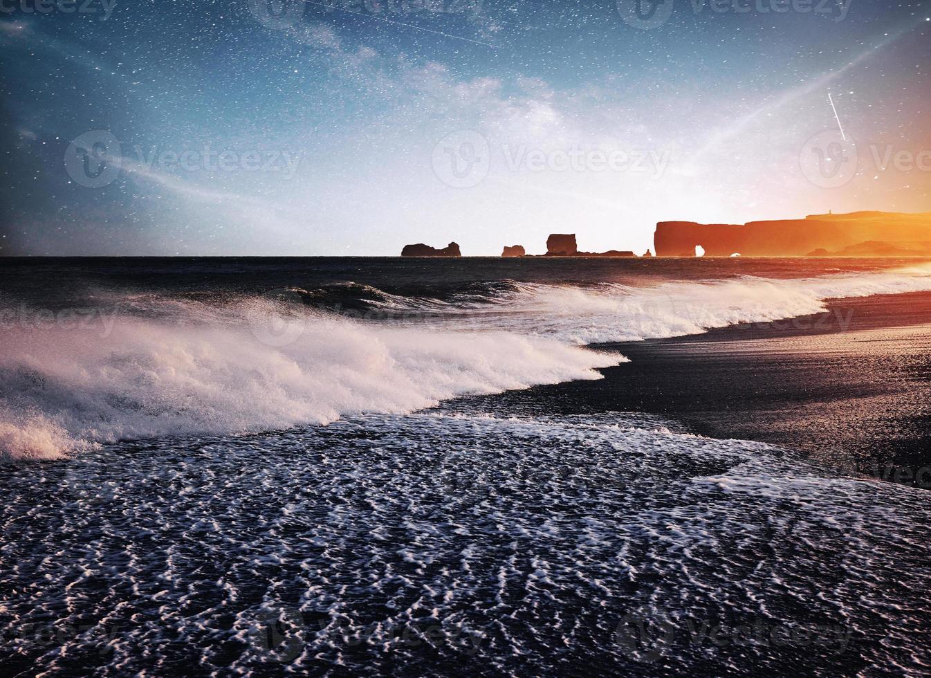 le dita dei troll delle rocce. scogliere di reynisdrangar. spiaggia di sabbia nera. Islanda. fantastico il cielo stellato e la via lattea foto