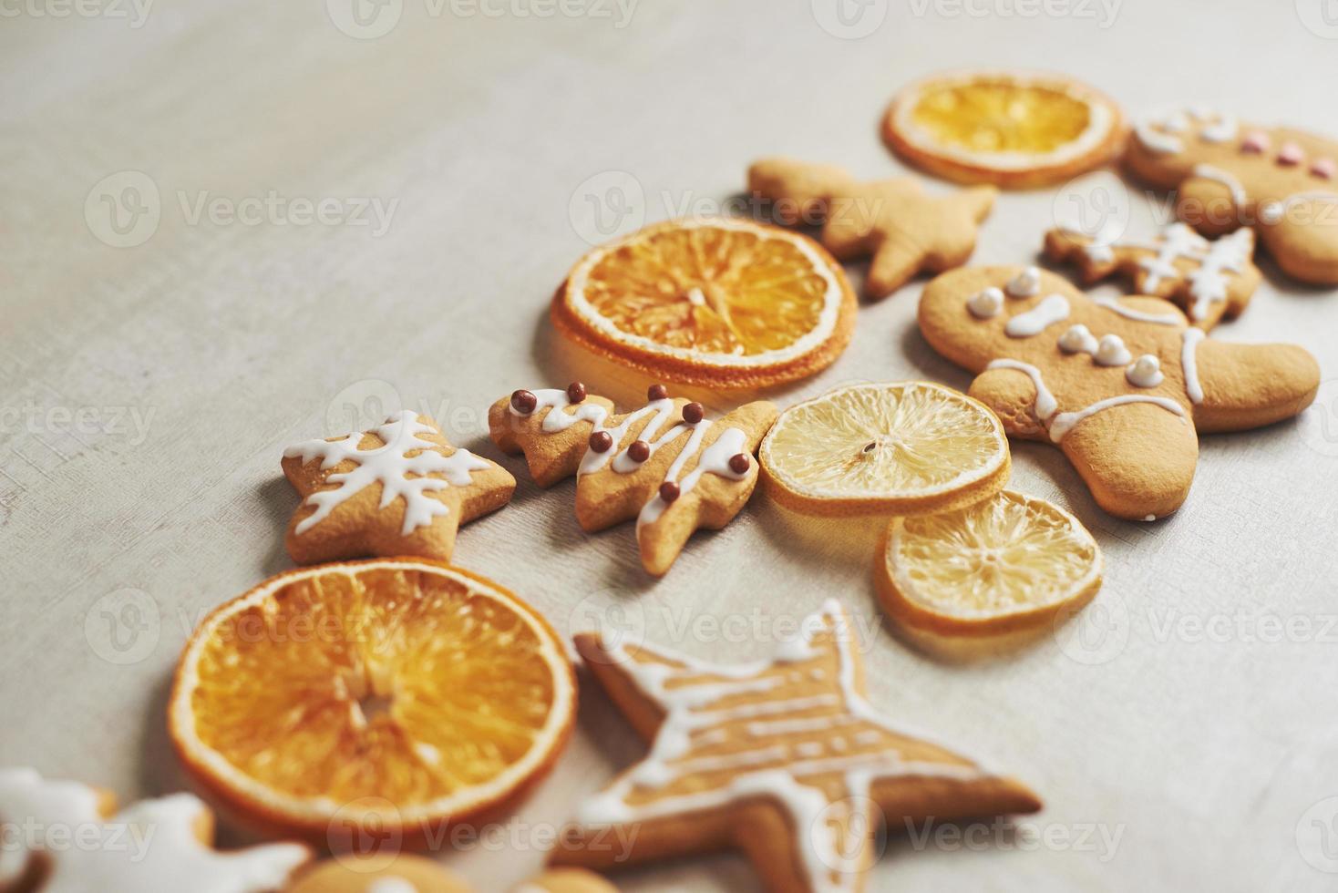 biscotti di pan di zenzero di Natale e arancia secca e spezie sul tavolo bianco foto