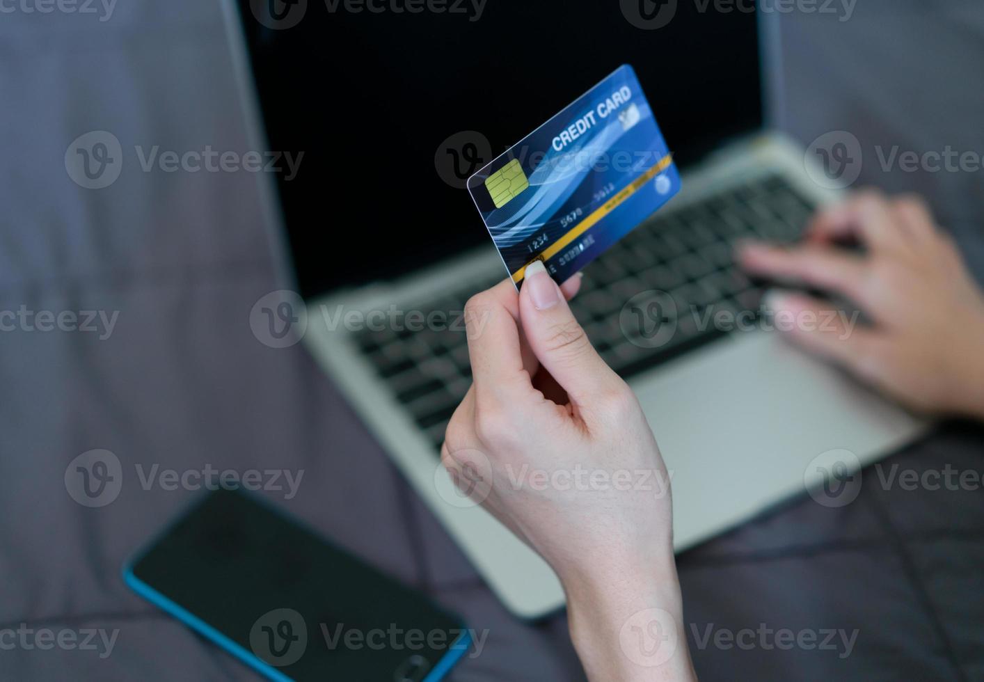 mano donna in possesso di carta di credito per lo shopping online. tecnologia e business moderno foto