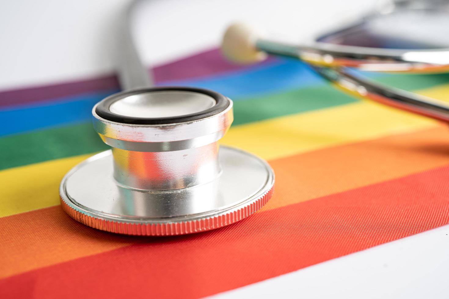 stetoscopio nero su sfondo bandiera arcobaleno, simbolo del mese dell'orgoglio lgbt celebra annuale a giugno sociale, simbolo di gay, lesbiche, bisessuali, transgender, diritti umani e pace. foto
