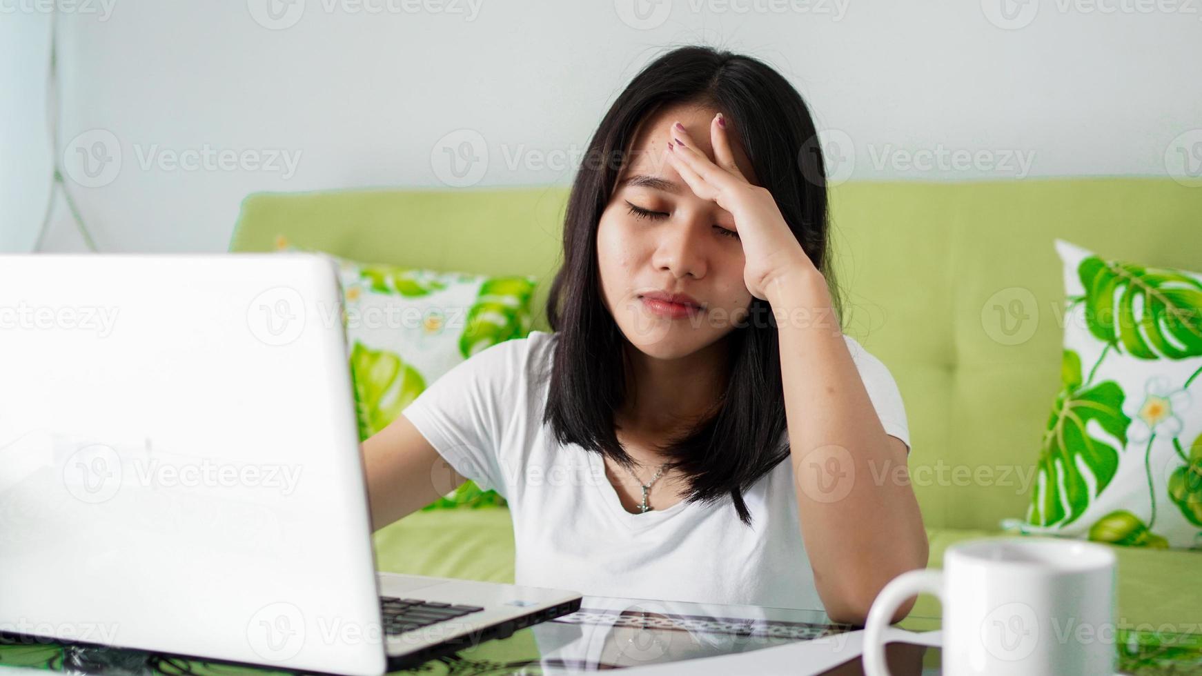 stressato asia donna lavora da casa con il computer a casa foto