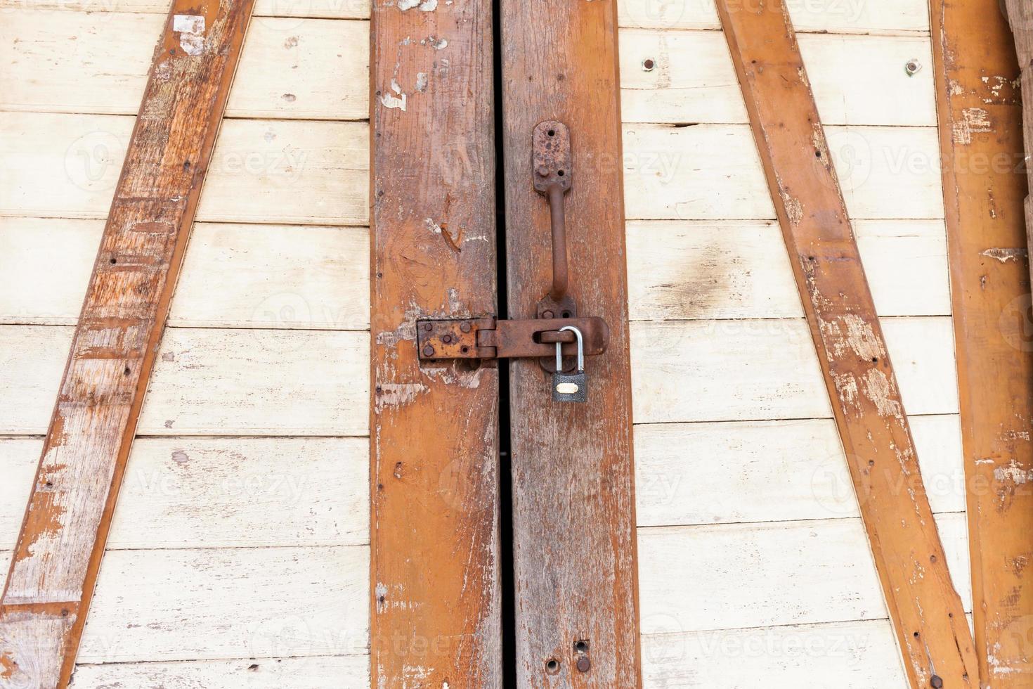 vecchio lucchetto arrugginito su una porta di legno foto