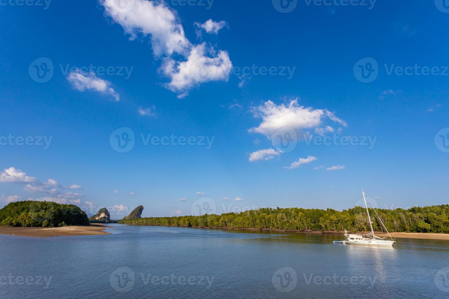 krabi, tailandia - 22 gennaio 2020 - bella vista naturale di barca a vela, barche, molo, foresta di mangrovie e montagna di khao khanab nam sul fiume krabi, krabi, tailandia. foto