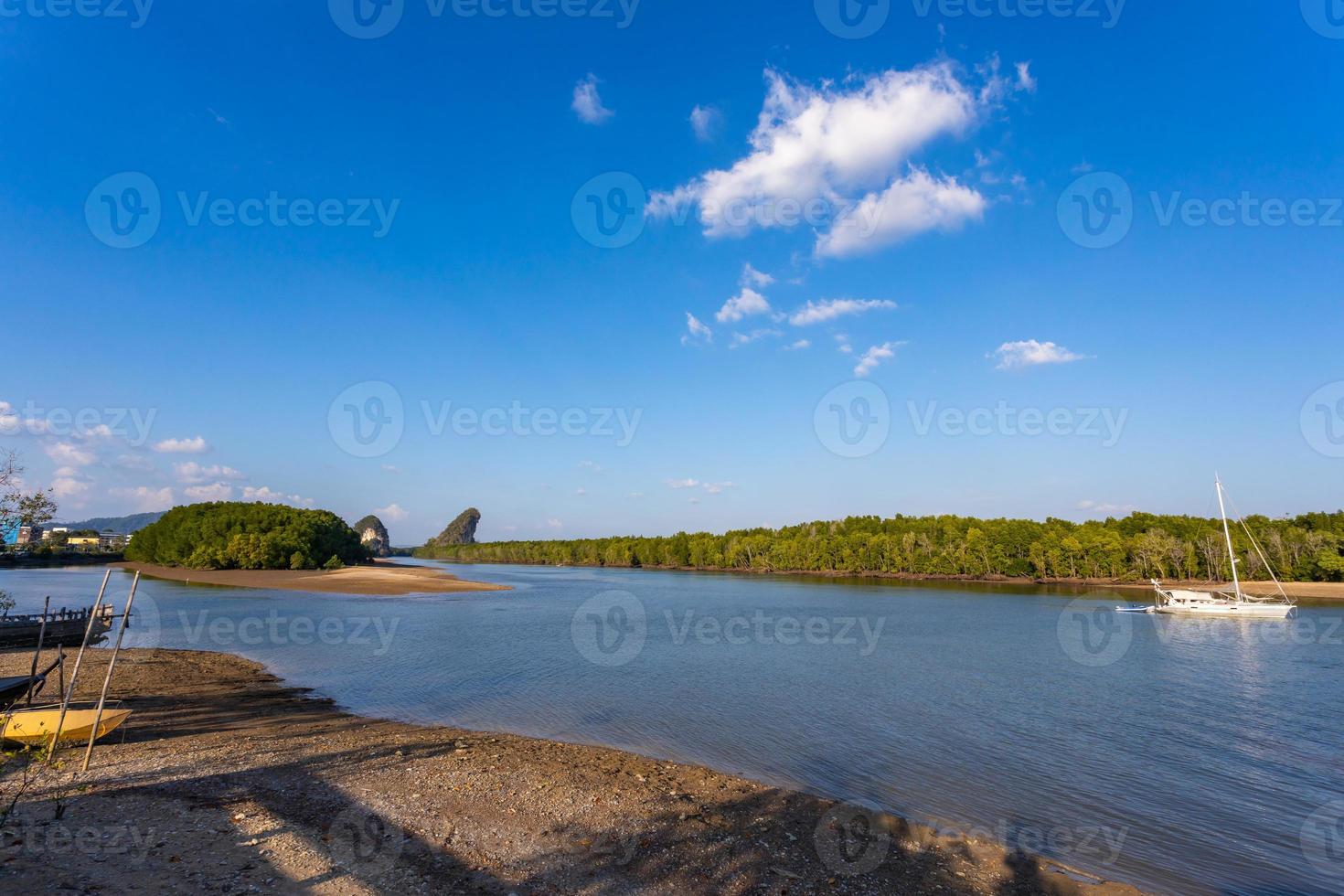 krabi, tailandia - 22 gennaio 2020 - bella vista naturale di barca a vela, barche, molo, foresta di mangrovie e montagna di khao khanab nam sul fiume krabi, krabi, tailandia. foto